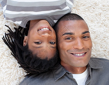 躺在地上微笑的非裔美国父亲和儿子图片