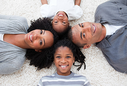 躺在地板上微笑的非裔美洲青年家庭图片