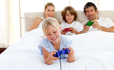 金发可爱的孩子 和她的家人玩电子游戏图片