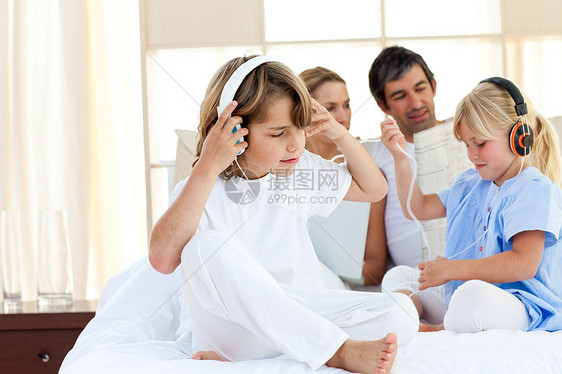 快乐的兄弟姐妹们用耳机听音乐图片