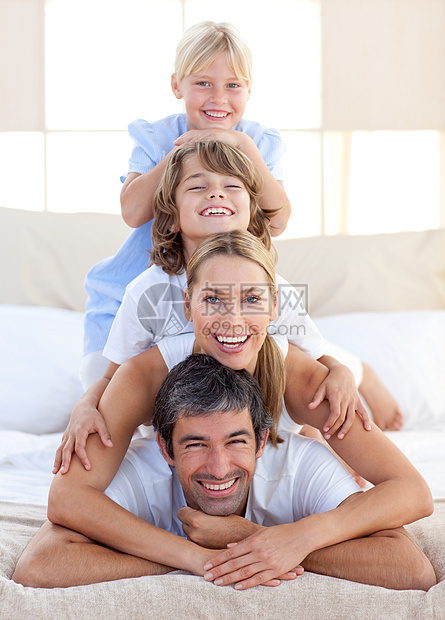 幸福的家庭在床上玩乐图片