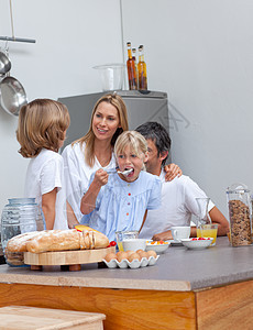 快乐的一家人一起吃早餐成人母亲童年享受橙汁食物男人厨房女士女性图片