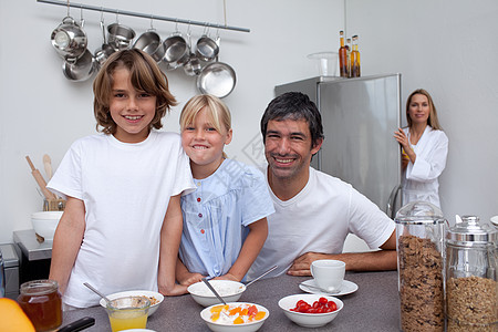 家人在吃早餐时微笑成人成年人桌子女性父母男性女孩童年孩子们谷物图片