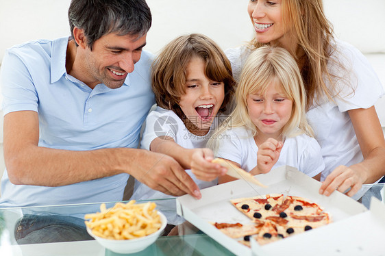 兴奋的孩子和父母一起吃比萨饼图片