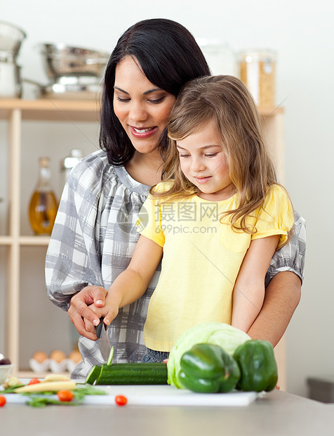美丽的母亲帮助女儿切菜的美丽母亲图片