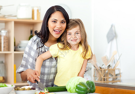 母亲和女儿在微笑时 一起切蔬菜图片
