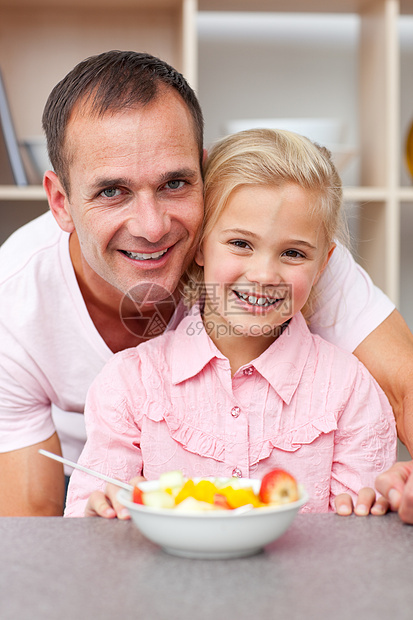 和父亲一起吃水果的快乐小女孩图片