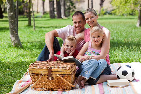 幸福家庭在公园玩乐乐趣野餐母亲享受父亲足球女孩阅读天空爸爸图片
