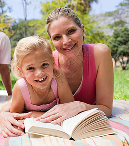 快乐的母亲和女儿在公园里读书图片