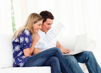 使用笔记本电脑坐在沙发上男人动画女朋友互联网迷恋亲热沙龙丈夫微笑电子图片