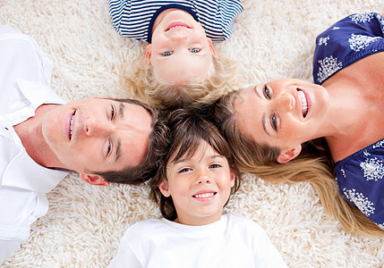 在墙到墙地毯上环绕一圈的幸福家庭图片