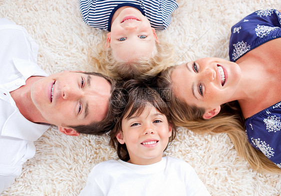在墙到墙地毯上环绕一圈的幸福家庭图片
