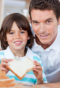 一个小男孩和他父亲吃面包的肖像图片