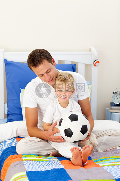 可爱的小男孩和他父亲玩足球比赛的爸爸图片