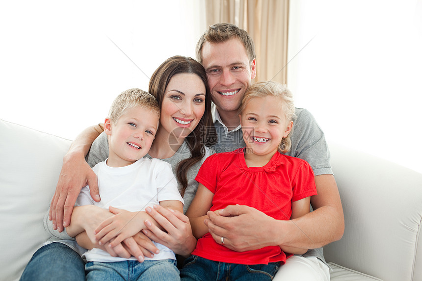 坐在沙发上的幸福家庭肖像男人男生母亲父亲女孩爸爸女士房间成人长椅图片