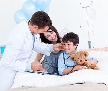 与一个小男孩和他母亲玩耍的迷人的医生图片