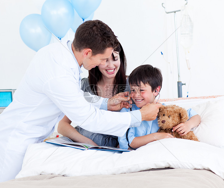 与一个小男孩和他母亲玩耍的微笑医生图片