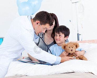 与一个小男孩和他母亲玩耍的看病医生图片