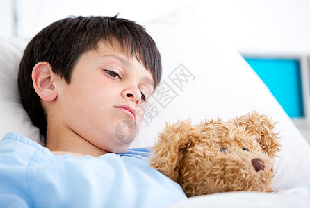 躺在医院床上的生病男孩的肖像图片