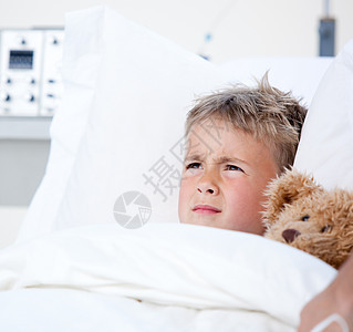 生病的小男孩躺在医院的床上男生童年玩具熊医疗医学白色临床疾病药品孩子图片