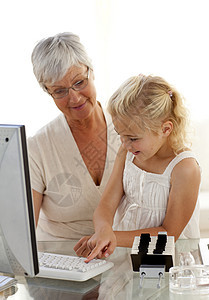 孙女向祖母解释如何使用电脑图片