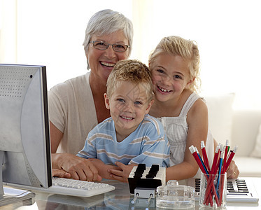 快乐的孩子用电脑和祖母一起使用电脑图片