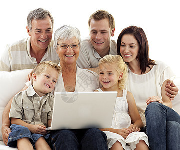 幸福家庭在客厅使用笔记本电脑男性父亲儿子长椅技术祖父姐姐乐趣母亲女性图片