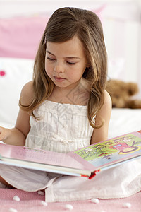 小女孩在床上读书女孩兴趣学习孩子教育知识分子阅读童年知识粉色图片