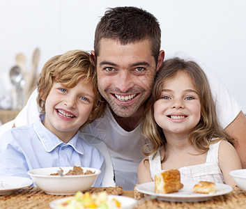 儿童与父亲一起吃早饭的肖像果汁桌子橙子孩子们家庭父母幸福孩子水果厨房图片