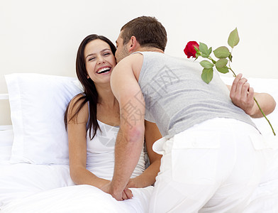 男人给他美丽的妻子一朵玫瑰和一个吻图片