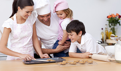家庭在厨房烘烤母亲儿子女儿父母饼干帮助烹饪童年女士食物图片