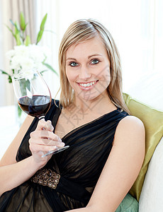 坐在沙发上喝红酒的漂亮女人图片
