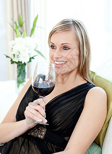 坐在沙发上喝红酒的开心女人图片