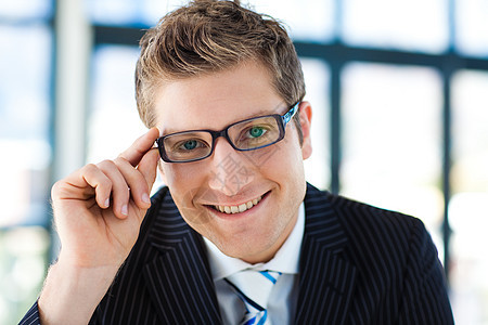 商务人士看着摄影机时戴眼镜的镜头商业眼镜衬衫照片建筑办公室套装男人眼睛商务图片