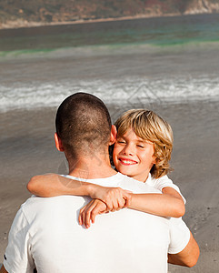 父亲和儿子在沙滩上拥抱图片