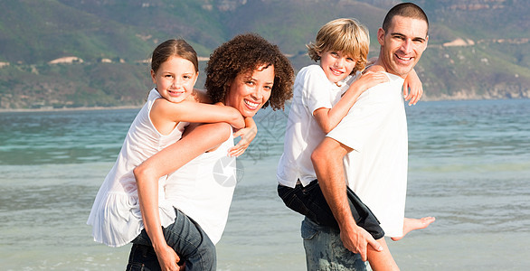 父母给两个年幼的孩子搭便车海洋女孩母亲兄弟假期男性男人乐趣波浪小猪图片