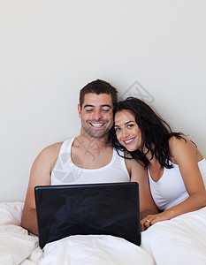 在床上使用笔记本电脑的情侣图片