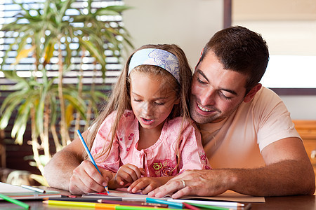 Radiant父亲帮助女儿做家庭作业夫妻男性女孩学生学习教育母亲桌子绘画姐姐图片