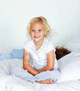坐在床上的小女孩在镜头前微笑着笑图片