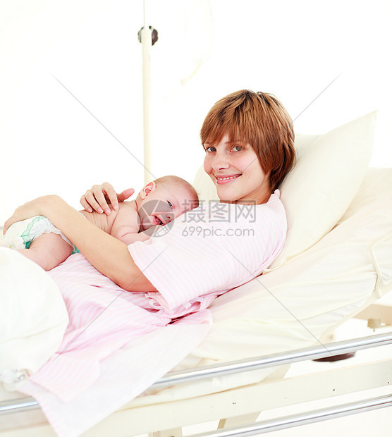 新生婴儿在床上的病人对着镜头微笑图片