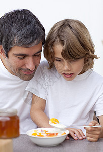 父亲和男孩一起吃早餐的肖像图片
