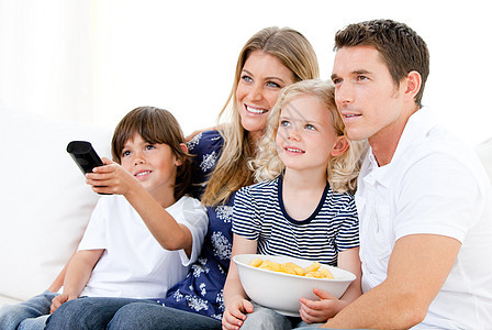 微笑的家庭在电视上看一部电影男人女孩屏幕兄弟动画女儿成人幸福孩子们后代图片