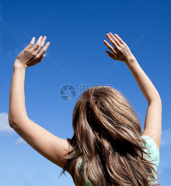 微笑的女人在户外对空气拳打脚踢胜利天空成功快乐天蓝色蓝天幸福女性女士阳光图片