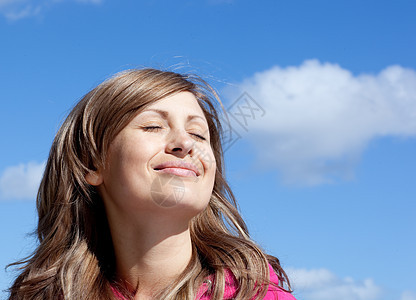 美丽的女人在户外放松蓝天天空气氛日光天气阳光蓝色微笑女性快乐图片