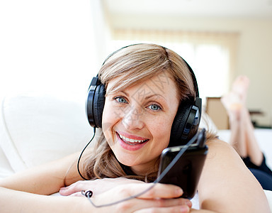 一个快乐的女人的肖像 用耳机收听音乐的声音图片