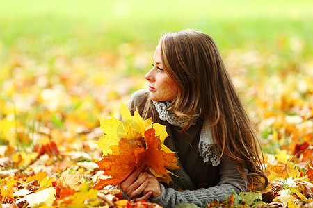 秋叶中的妇女脚尖橙子头发公园微笑乐趣女士毛衣季节女性团体图片