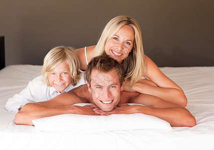 美丽的家人一起躺在床上玩得开心图片