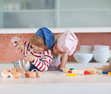 快乐的兄弟姐妹们做饼干青年食物厨房闲暇女性孩子们童年孩子烹饪女孩图片