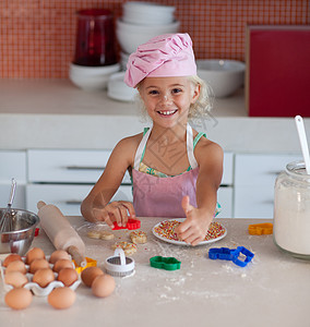 美丽的年轻女孩 在厨房的拇指上工作图片