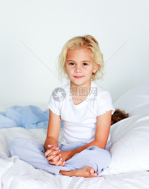 坐在床上的可爱金发女孩图片